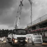 Betonpumpe-im-einsatz,-regen-hochformat-pumpt-beton-in-oberes-stockwerk