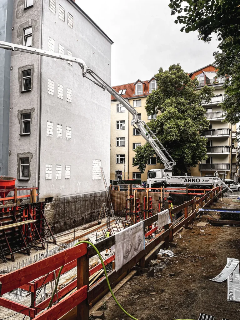 Arnos_betonpumpen_service_pumpe_mit_arm_weit_über_baugrube